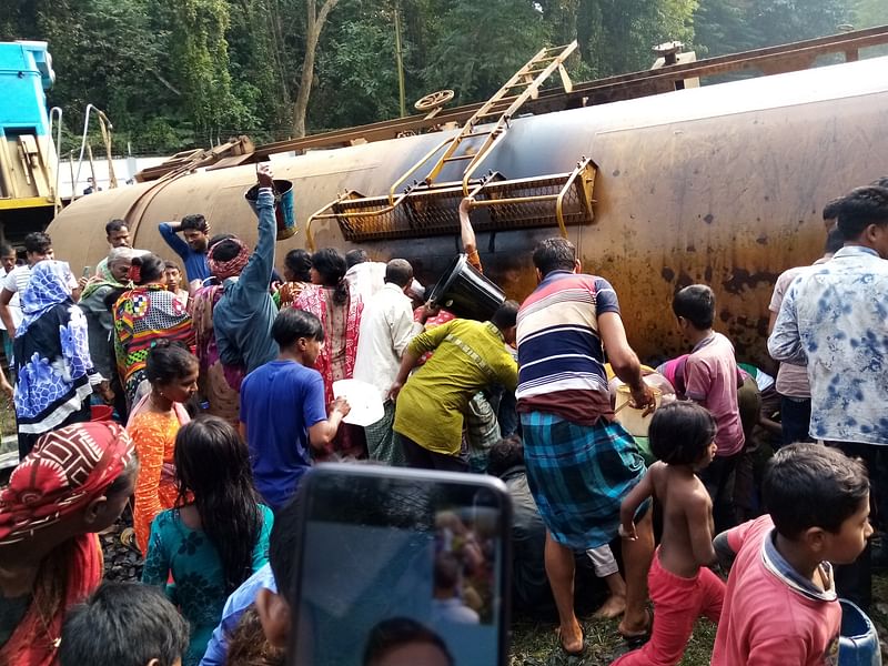 হবিগঞ্জের মাধবপুর উপজেলার শাহজিবাজার রেলস্টেশনের কাছে লাইনচ্যুত হওয়া ট্যাংকার থেকে জ্বালানি তেল সংগ্রহ করতে হুমড়ি খেয়ে পড়েছে মানুষ। রোববার দুপুরে তোলা ছবি