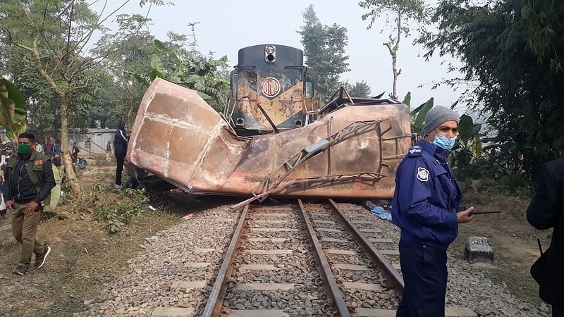 দুর্ঘটনায় দুমড়ে–মুচড়ে যাওয়া বাসটি পড়ে আছে রেললাইনে