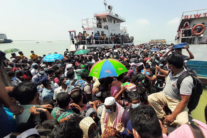 মানিকগঞ্জের পাটুরিয়া ঘাটে আজ দুপুরে যাত্রীর চাপ বেড়ে যায়। এই যাত্রীরা ফেরিতে গাদাগাদি করে নদী পার হন