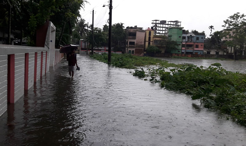 নালা উপচে পানি উঠে তলিয়ে গেছে সড়ক। শুক্রবার বিকেলে মৌলভীবাজার শহরের গির্জাপাড়ায়