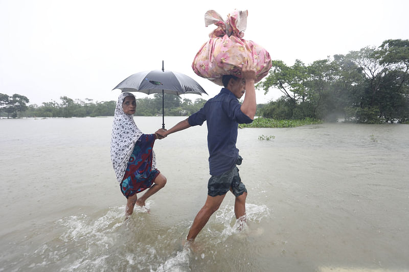 সিলেট-কোম্পানীগঞ্জ-ভোলাগঞ্জ সড়ক ধরে আশ্রয়কেন্দ্রের দিকে যাচ্ছেন দুজন। ছবি শুক্রবার দুপুরে তোলা