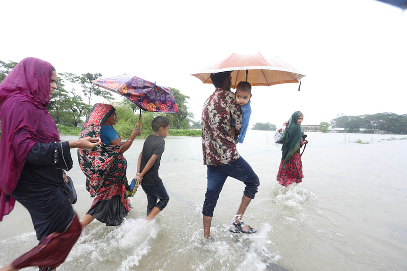 তলিয়ে যাওয়া সিলেট-কোম্পানী-ভোলাগঞ্জ সড়ক দিয়ে নিরাপদ আশ্রয়ে যাওয়ার চেষ্টা করছেন বন্যাকবলিত এলাকার মানুষজন। শুক্রবার দুপুরে কোম্পানীগঞ্জের বর্ণি এলাকায়