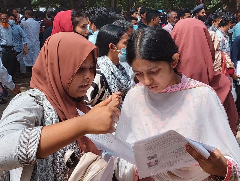 রাজশাহী বিশ্ববিদ্যালয়ে ২০২১-২২ শিক্ষাবর্ষে স্নাতক (সম্মান) প্রথম বর্ষে ভর্তি পরীক্ষা শেষে হল থেকে বের হয়ে প্রশ্নপত্র দেখছেন পরীক্ষার্থী।