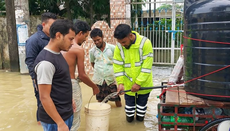 সিলেটে স্মরণকালের ভয়াবহ বন্যায় বন্যার্ত মানুষের সেবায় ব্যস্ত সফি আহমদ (ডানে)