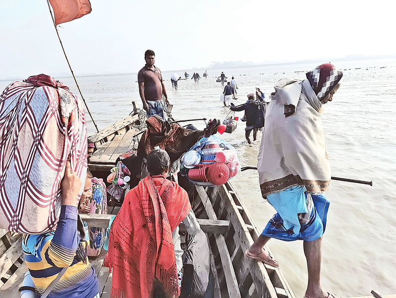 ভাটার সময় ট্রলারের মাঝি যাত্রীদের মেঘনা নদীর মধ্যে নামিয়ে দিচ্ছেন। যাত্রীরা পানি ভেঙে যাচ্ছেন তীরের দিকে। ৪ ফেব্রুয়ারি ভোলার দৌলতখান উপজেলার মদনপুর রাস্তারমাথা ঘাটে