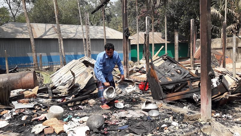 ঘরের সঙ্গে পুড়ে যাওয়া হাঁড়ি-পাতিল খুঁজে বের করছেন ট্রাকচালক আবদুল হাকিম। আজ শনিবার সকালে পঞ্চগড় শহরের উপকণ্ঠে আহম্মদনগর এলাকায়