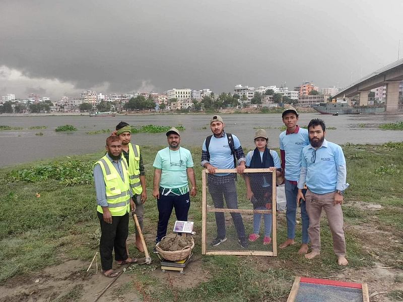 বসিলা সেতুর কাছে বুড়িগঙ্গার পাড়ে ক্যাপসের কর্মীরা মাটি সংগ্রহ করছেন।