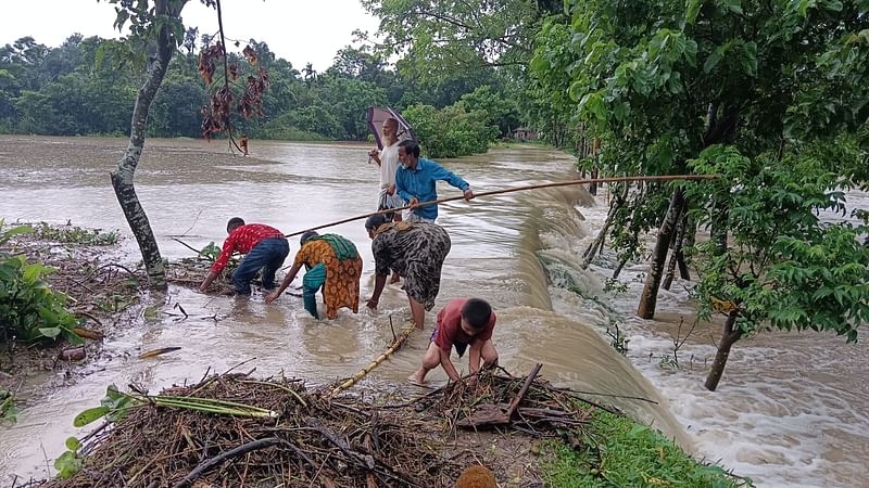 পাহাড়ি ঢলের পানি সড়ক উপচে তীব্র বেগে পড়ছে খালে। রোববার সকালে সুনামগঞ্জের দোয়ারাবাজার উপজেলার সুরমা ইউনিয়নের টিলাগাঁও গ্রামে