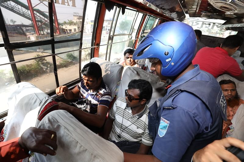 বাসের ভেতর যাত্রীদের জিজ্ঞাসাবাদ করা হচ্ছে। আমিনবাজার, সাভার