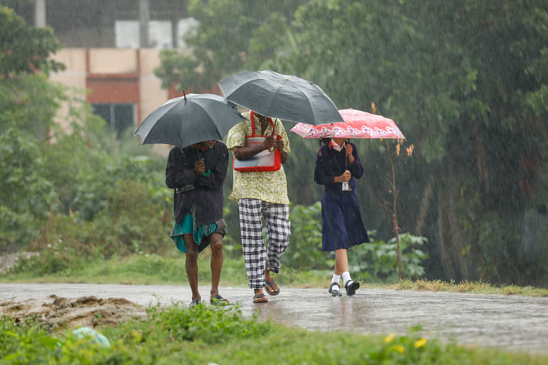 গুঁড়ি গুঁড়ি বৃষ্টি উপেক্ষা করে গন্তব্যে ছুটছেন মানুষ। শুক্রবার সকালে খুলনা শহরের বাস্তুহারা এলাকায়