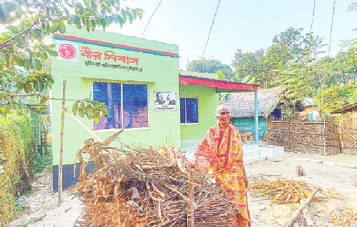 অসচ্ছল মুক্তিযোদ্ধাদের জন্য সরকারের উপহারের বাড়ি বীর নিবাসের সামনে বীর মুক্তিযোদ্ধা নন্দলালের স্ত্রী কিশোরী রানী। সম্প্রতি ঠাকুরগাঁওয়ের পীরগঞ্জ উপজেলার মালিগাঁও গ্রামে