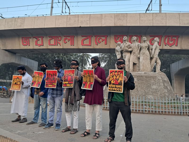 রাজু ভাস্কর্যের পাদদেশে চোখে কালো কাপড় বেঁধে মৌন মানববন্ধন করা হয়। ঢাকা বিশ্ববিদ্যালয়, ৫ জানুয়ারি