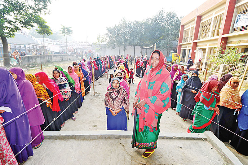 দ্বাদশ জাতীয় সংসদ নির্বাচনে ভোট দিতে লাইনে দাঁড়িয়েছেন ভোটাররা। ৭ জানুয়ারি কুমিল্লার ধামতি উত্তর সরকারি প্রাথমিক বিদ্যালয় ভোটকেন্দ্রে