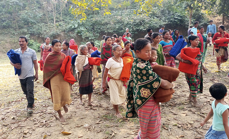 শেরপুরের নালিতাবাড়ী উপজেলার সীমান্তঘেঁষা খলচন্দা গ্রামে প্রথম আলো ট্রাস্টের দেওয়া কম্বল নিয়ে বাড়ি ফিরছেন কোচপাড়ার নারী-পুরুষেরা। আজ রোববার দুপুরে কোচপাড়া কালীমন্দির এলাকায়