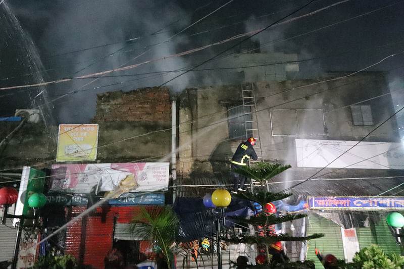 আগুন নেভানোর চেষ্টা করছেন ফায়ার কর্মীরা। সোমবার রাতে রাজশাহী নগরের আরডিএ মার্কেটে