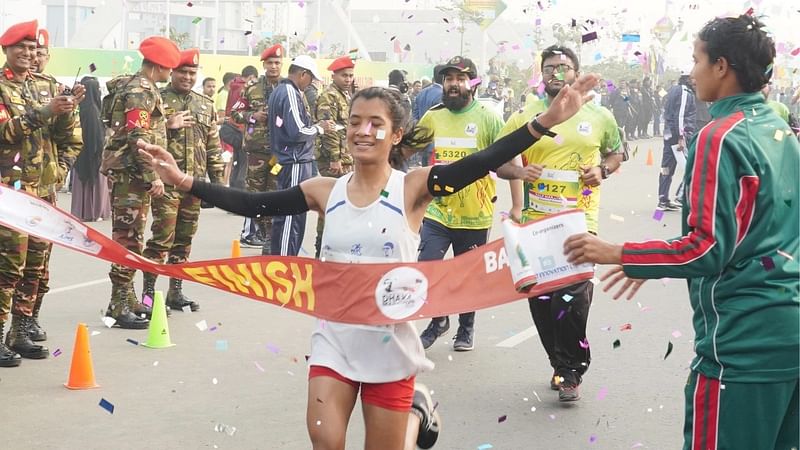 বঙ্গবন্ধু ঢাকা ম্যারাথনে ফিনিশ লাইন ছোঁয়ার পর এক প্রতিযোগীর উচ্ছ্বাস। আজ সকালে বা নৌ জা শেখ মুজিব ঘাঁটির শেখ হাসিনা সরণিতে