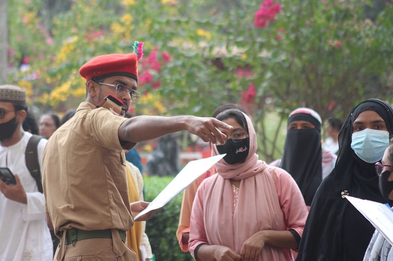 এক পরীক্ষার্থীকে পরীক্ষার কক্ষে যেতে সহযোগিতা করছেন এক স্বেচ্ছাসেবক