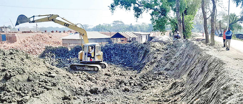 বন্যা নিয়ন্ত্রণ বাঁধের পাশ থেকে ইট তৈরির জন্য এক্সকাভেটর দিয়ে মাটি কেটে নিয়ে যাচ্ছেন ইটভাটার মালিক। গত মঙ্গলবার বরগুনার আমতলী উপজেলার গুলিশাখালী গ্রামে