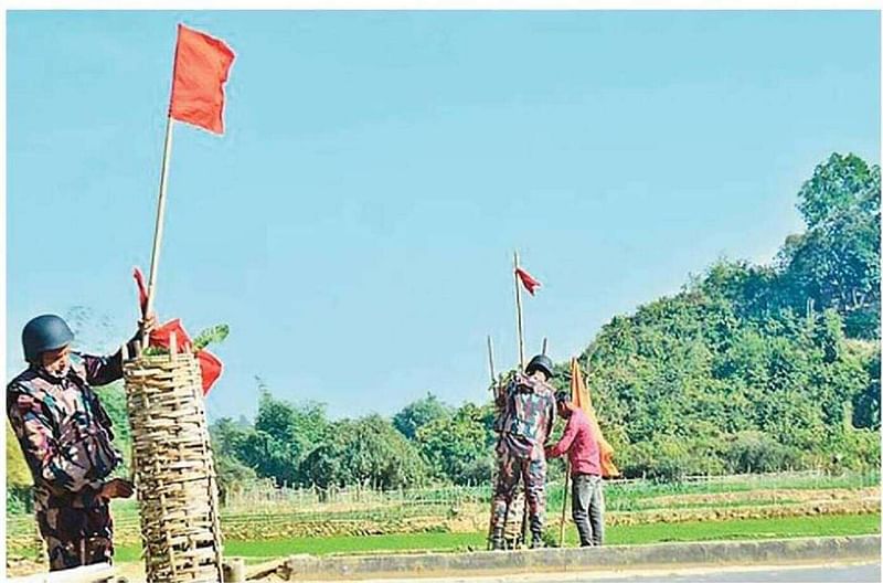 বান্দরবানের নাইক্ষ্যংছড়ি উপজেলার তুমব্রু এলাকায় সংকেতমূলক লাল পতাকা টাঙাচ্ছেন বিজিবির সদস্যরা