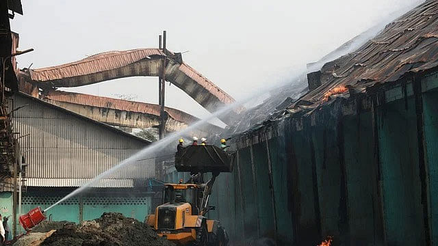 চট্টগ্রামের কর্ণফুলী থানা এলাকায় এস আলম গ্রুপের চিনিকলের গুদামের আগুন নেভানোর কাজ করছে ফায়ার সার্ভিসের কর্মীরা। আজ সকালে তোলা