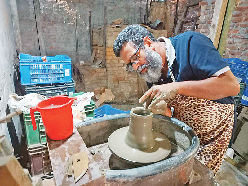 ঢাকার সাভারের কাতলাপুরে হুইলে পটারি বানাতে ব্যস্ত শিল্পী বখতিয়ার কারিগর