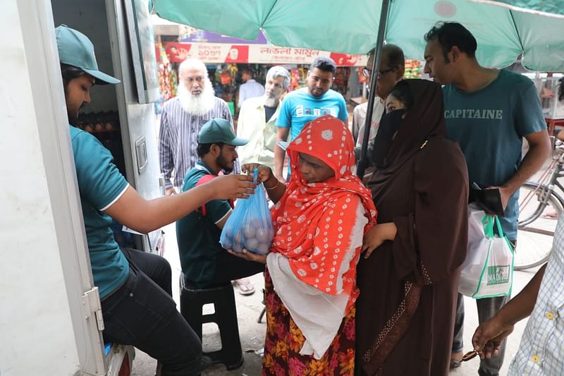 প্রাণিসম্পদ অধিদপ্তরের ভ্রাম্যমাণ ভ্যান থেকে ডিম কিনছেন এক ক্রেতা। নিকেতন বাজার সড়ক, মহাখালী দক্ষিণপাড়া, ঢাকা