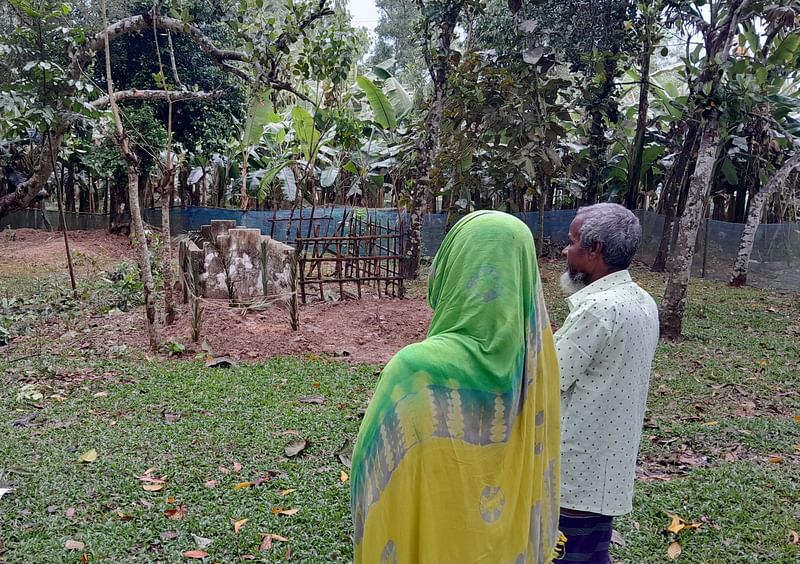 সোলাইমানের কবরের সামনে দাঁড়িয়ে আছেন মা–বাবা। মঙ্গলবার বিকেলে ময়মনসিংহের ফুলবাড়িয়া উপজেলার ভালুকজান গ্রামে