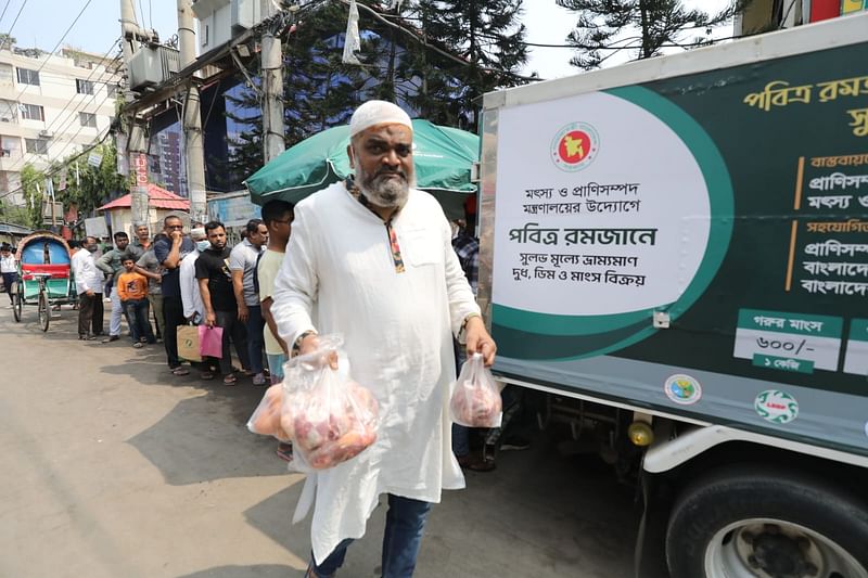 প্রাণী সম্পদ অধিদপ্তরের ভ্রাম্যমাণ বিক্রয় কেন্দ্র থেকে মাংস, ডিম, দুধ কিনছেন মানুষ। রাজধানীর মোহাম্মদপুরের সূচনা কমিউনিটি সেন্টারের সামনে