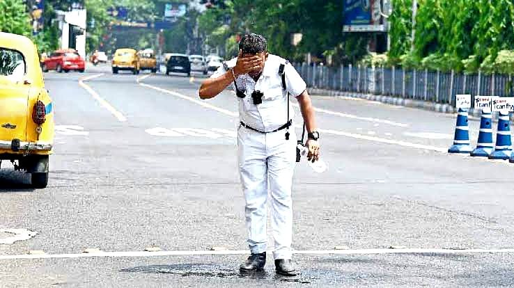 ট্রাফিক পুলিশের এক কর্মী মুখে পানি ছিটাচ্ছেন