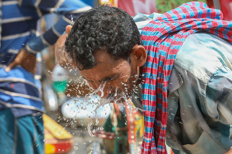 মুখ পানি দিয়ে ধুয়ে গরমের কারণে ক্লান্তি দূর করার চেষ্টা করছেন এক ব্যক্তি। রাজধানীর মতিঝিল থেকে তোলা