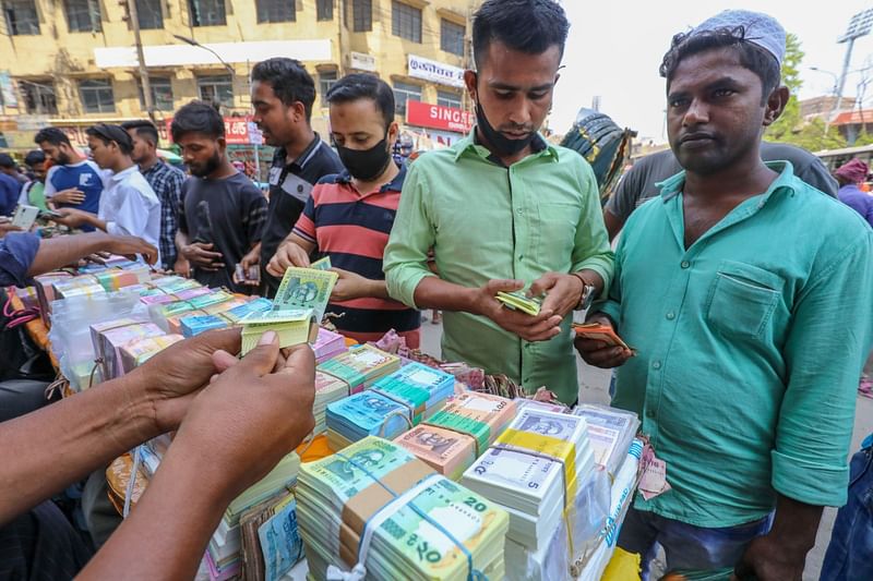 পবিত্র ঈদুল ফিতর উপলক্ষে ঢাকায় গুলিস্তানের ভ্রাম্যমাণ দোকানীর কাছ থেকে নতুন টাকা সংগ্রহ করছেন সাধারণ মানুষ