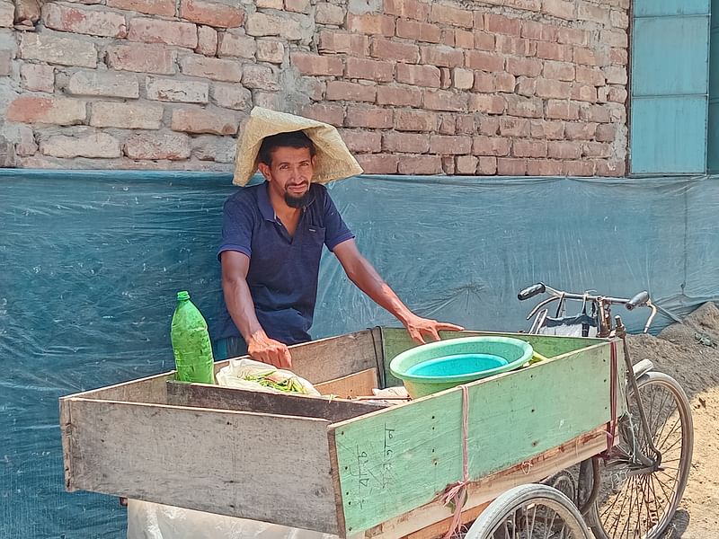 প্রচণ্ড রোদের মধ্যে একটি ভবনের পাশে ছায়ায় আশ্রয় নিয়েছেন সবজি বিক্রেতা আখতারুজ্জামান। মাথায় দিয়েছেন সবজির ব্যাগ। বৃহস্পতিবার দুপুরে নগরের নাজিরঘাট এলাকায়