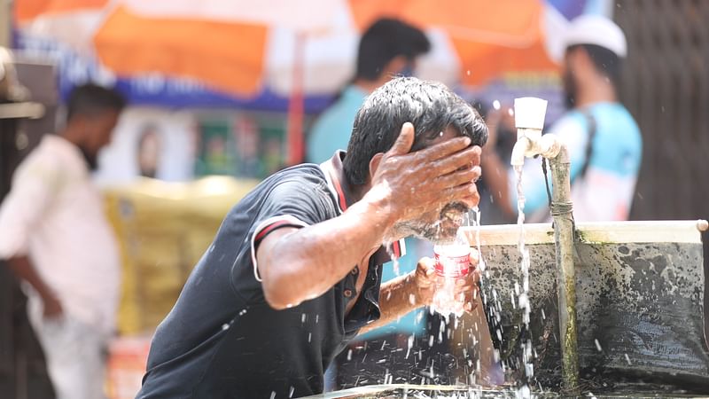 চোখমুখে পানির ঝাপটা দিচ্ছেন এই পথচারী। নারায়ণগঞ্জের ২ নম্বর রেলগেট এলাকায়