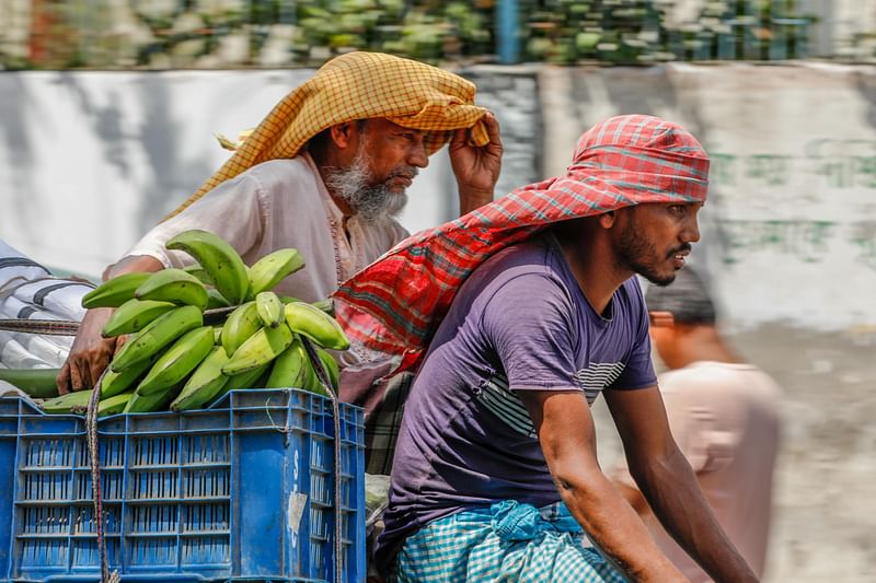 প্রচণ্ড গরমে বেশি কষ্ট পাচ্ছেন বাইরে কাজ করতে বের হওয়া মানুষেরা। গগনবাবু সড়ক, খুলনা, ২২ এপ্রিল