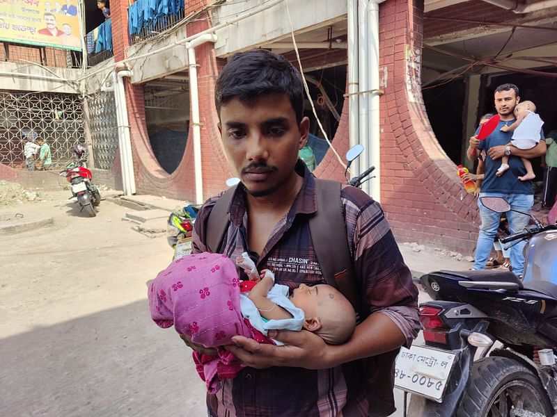 সন্তানকে কোলে নিয়ে  ইব্রাহিম হোসেন