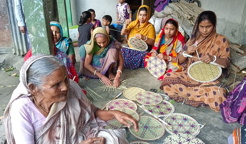 কিশোরগঞ্জের নিকলীর দামপাড়া ইউনিয়নের টেকপাড়া গ্রামের নারীরা তালপাতার হাতপাখা বানানোর কাজে ব্যস্ত। শুভা রানী সূত্রধরের (বাঁ থেকে প্রথম) কাছ থেকে অন্যরা এই কাজ শিখেছিলেন