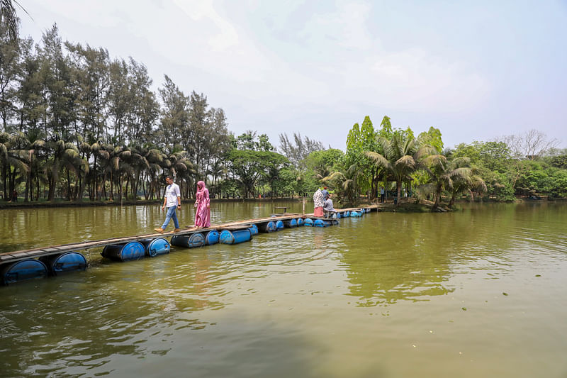 কাঠের পাটাতন আর প্লাস্টিকের ড্রাম দিয়ে বানানো হয়েছে ভাসমান সেতু