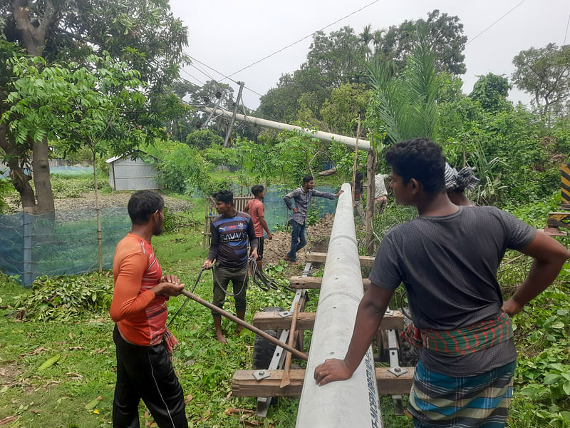 ঘূর্ণিঝড় রিমালের তোড়ে বিদ্যুতের খুঁটি ভেঙে পড়েছে। বিদ্যুৎ বিভাগ সকাল থেকেই লাইন মেরামতের কাজ শুরু করেছে। কালীগঞ্জ, সাতক্ষীরা, ২৮ মে