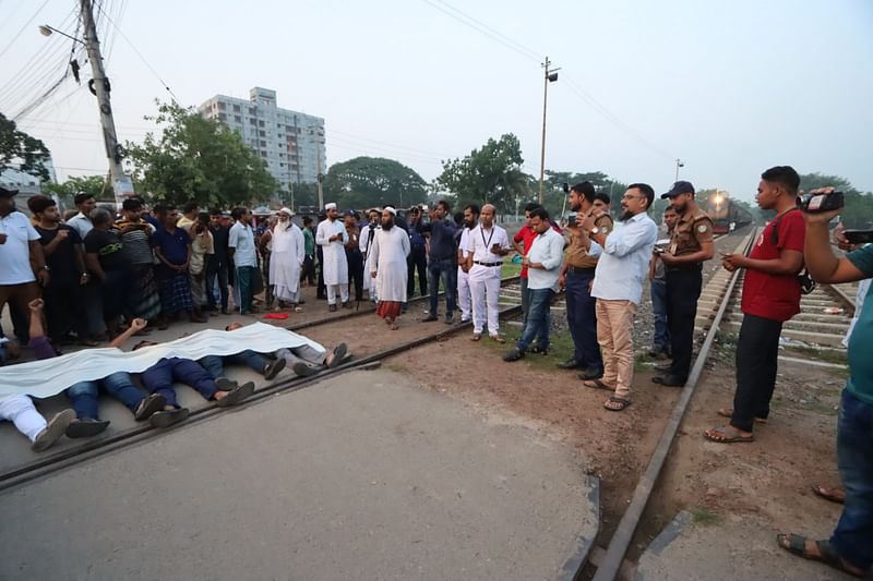 আন্দোলনকারীরা কাফনের কাপড় শরীরে জড়িয়ে রেললাইনের ওপর শুয়ে পড়েন। আজ শনিবার ভোরে ফরিদপুর রেলস্টেশন এলাকায়