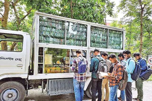 বিশ্বসাহিত্য কেন্দ্রের ভ্রাম্যমাণ পাঠাগার থেকে বই নিচ্ছেন পাঠকেরা