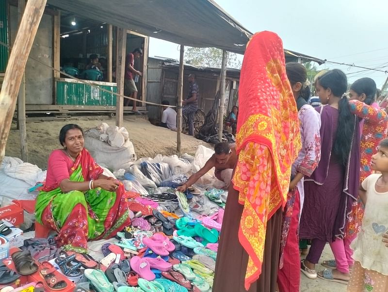 প্রায় ১০ কিলোমিটার দূর থেকে অনিতা সরকার হাটে এসেছেন প্লাস্টিকের জুতা স্যান্ডেলের পসরা নিয়ে, ১৮ মে, বুড়ির ডাবুর হাট, কৈলাসগঞ্জ, দাকোপ