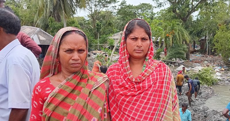 বেড়িবাঁধ ভেঙে ঘর হারিয়েছেন স্বপ্না ও সুনীতা সরদার। স্বেচ্ছাশ্রমের ভিত্তিতে পাশে বেড়িবাঁধ মেরামত করা হচ্ছে। বুধবার দুপুরে খুলনার দাকোপ উপজেলার বটবুনিয়া বাজারসংলগ্ন সরদারবাড়ি এলাকায়