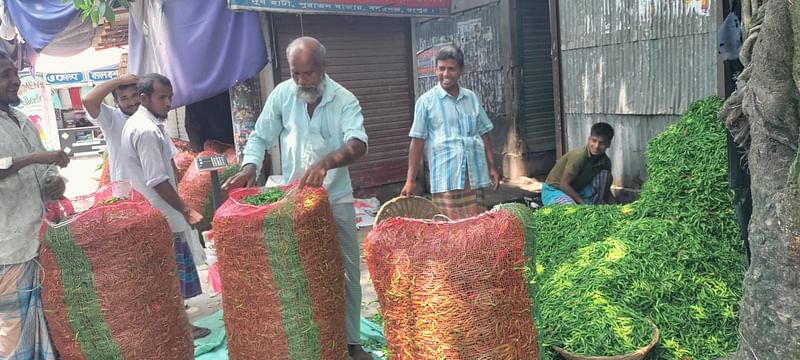 কৃষকের কাছ থেকে মরিচ কিনে বস্তায় ভরা হচ্ছে। গত রোববার রংপুরের বদরগঞ্জ উপজেলার হাসপাতালপাড়া গ্রামে