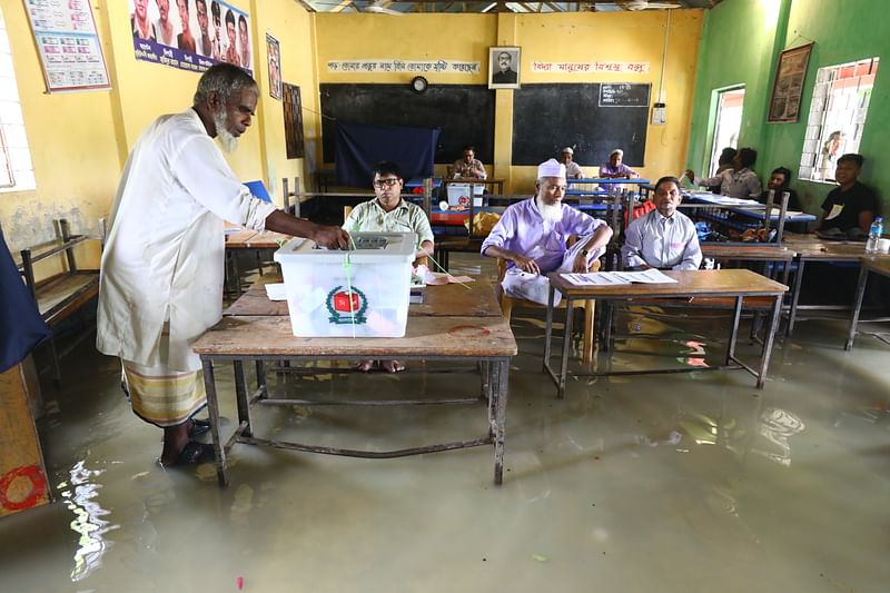 বন্যার পানির মধ্যেই ভোটকেন্দ্রে ভোট দিচ্ছেন ভোটাররা। আজ সিলেটের জকিগঞ্জের নিদনপুর সরকারি প্রাথমিক বিদ্যালয় ভোটকেন্দ্রে