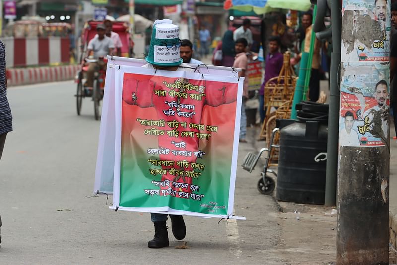 সড়ক দুর্ঘটনা রোধে সচেতনতা তৈরির জন্য কাকতাড়ুয়া সাজে রেজাউল ইসলামের অভিনব প্রচারণা। গতকাল রংপুর নগরের স্টেশন সড়ক এলাকায়