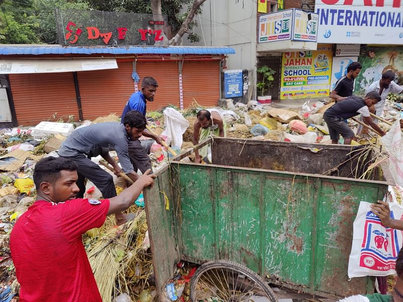 সহকর্মীদের সঙ্গে আবর্জনা পরিষ্কার করছেন ইকবাল (বাঁ থেকে দ্বিতীয় কালো শার্ট পরিহিত)