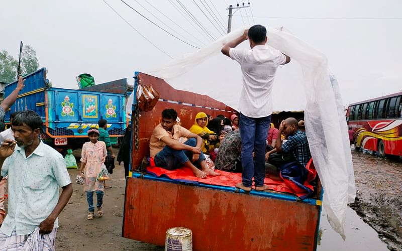 ট্রাকে করে কর্মস্থলে ফিরছেন পোশাক কারখানার শ্রমিকেরা। আজ শনিবার দুপুরে শেরপুরে ঢাকা বাস টার্মিনালে