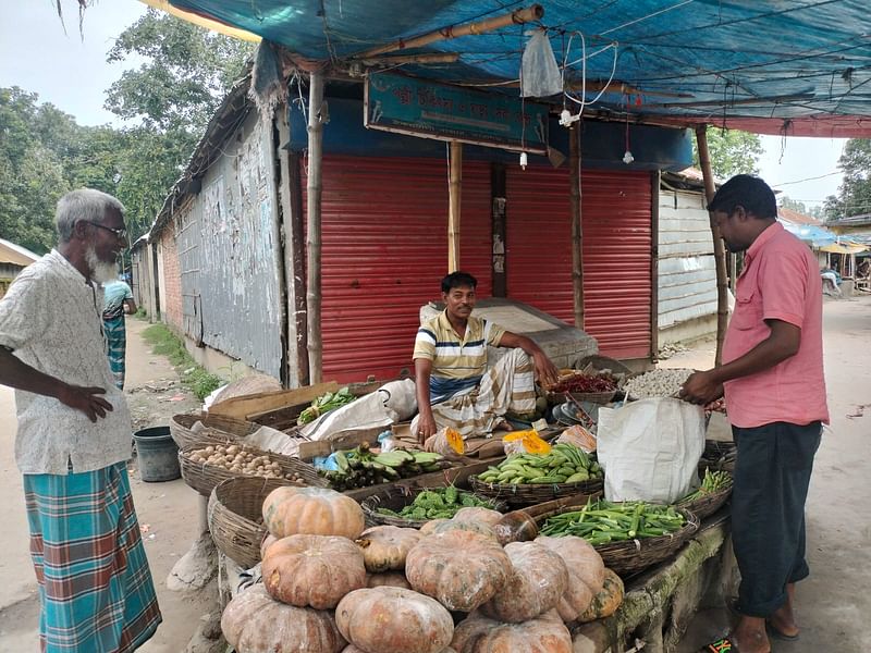 রংপুরের তারাগঞ্জে সবজির দোকানের সামনে দুই ক্রেতা। গতকাল শনিবার বিকেলে