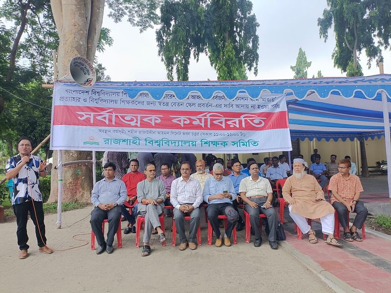 প্রত্যয় স্কিম প্রত্যাহারের দাবিতে রাজশাহী বিশ্ববিদ্যালয়ে সর্বাত্মক কর্মবিরতি ও অবস্থান কর্মসূচি পালন করেছেন শিক্ষকেরা। আজ সোমবার বেলা ১১টার দিকে বিশ্ববিদ্যালয়ের সিনেট ভবনের সামনে