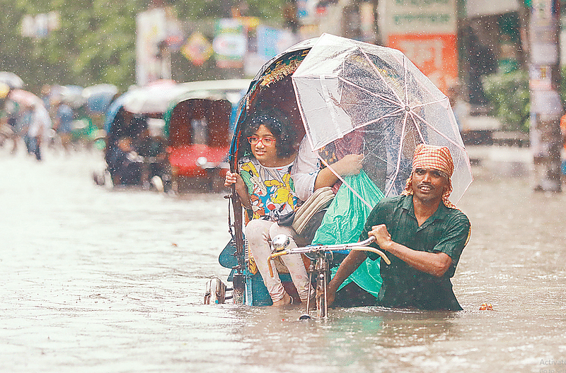 জলাবদ্ধ সড়কে রিকশাযোগে কোমরসমান পানি পার হচ্ছেন চলাচলকারীরা। গতকাল বেলা ১১টায় রাজধানীর গ্রিন রোডে